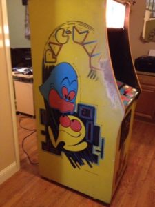 Unrestored Pac-Man machine with worn paint in a specific place on the left-hand side.