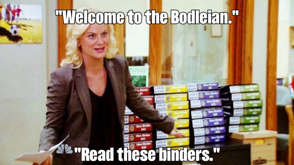Leslie Knope (Parks & Rec) presents a pile of binders, saying 