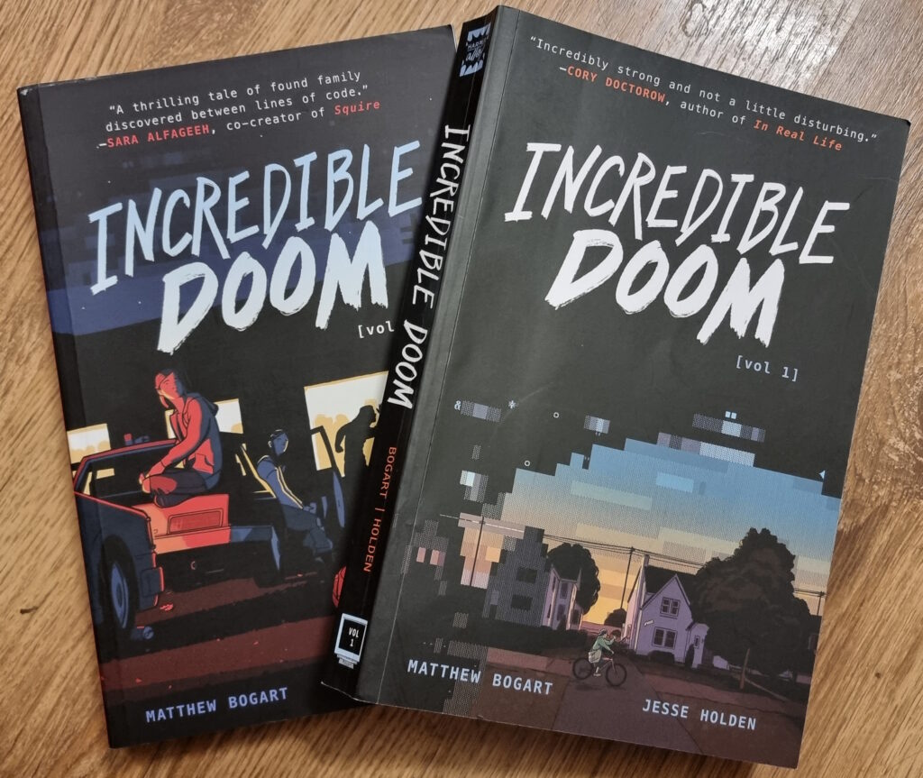 Softcover bound copies of volumes 1 and 2 of Incredible Doom, on a wooden surface.