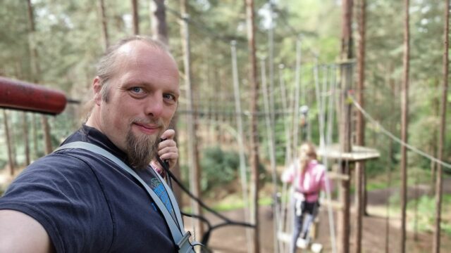 Dan takes a selfie from a high-ropes course, up a tree.